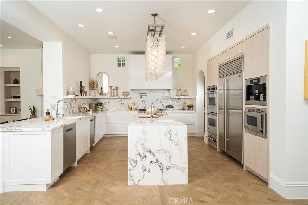 17 Boardwalk Newport Beach, CA 92660 - Photo 7 of 58 a kitchen with stainless steel appliances kitchen island granite countertop a refrigerator oven a sink dishwasher and white cabinets with wooden floor