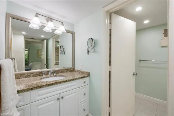a bathroom with a granite countertop sink a large mirror and a shower