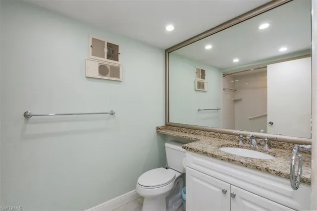 a bathroom with a granite countertop sink a toilet and a mirror