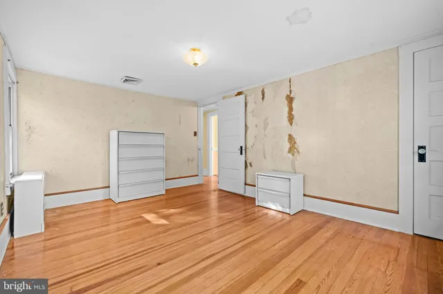 a view of an empty room with wooden floor