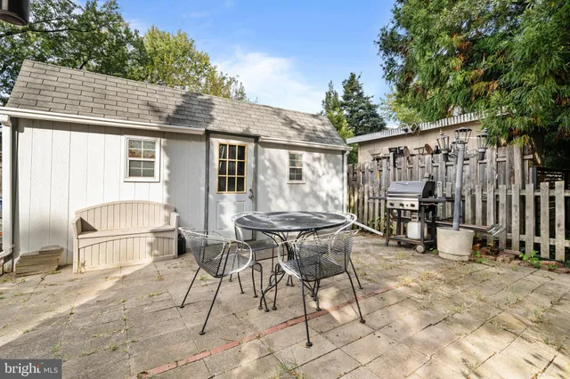 a patio with table and chairs and potted plants