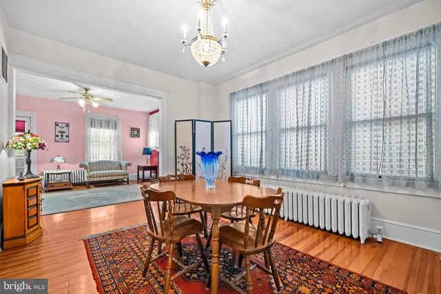a dining room with furniture a chandelier and wooden floor