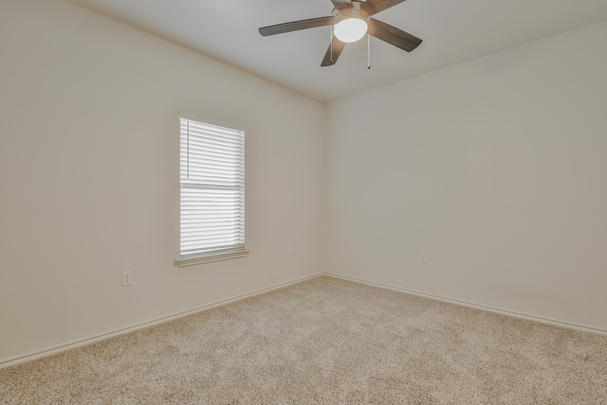 5512 Kemper Street Lubbock, TX 79416 - Photo 11 of 34 an empty room with a window and a fan