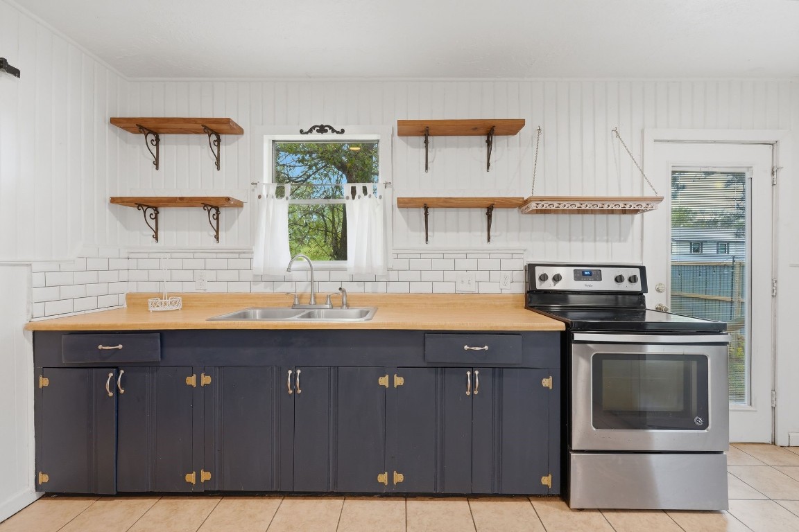 11757 Calvary Road Willis, TX 77318 - Photo 9 of 33 This kitchen offers a great balance of style and function, featuring modern appliances, open shelving, and plenty of space for everyday cooking.