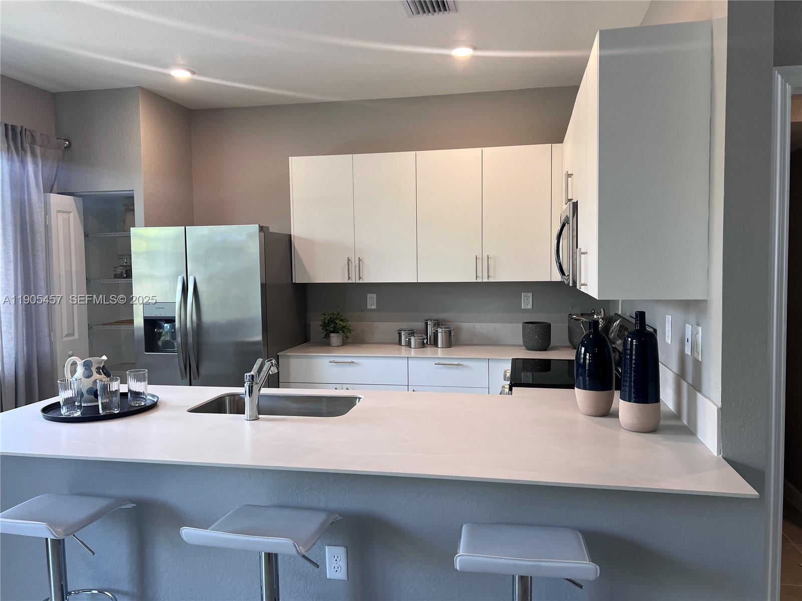 640 Southeast 14th Street Homestead, FL 33034 - Photo 2 of 29 a kitchen with a sink refrigerator and cabinets