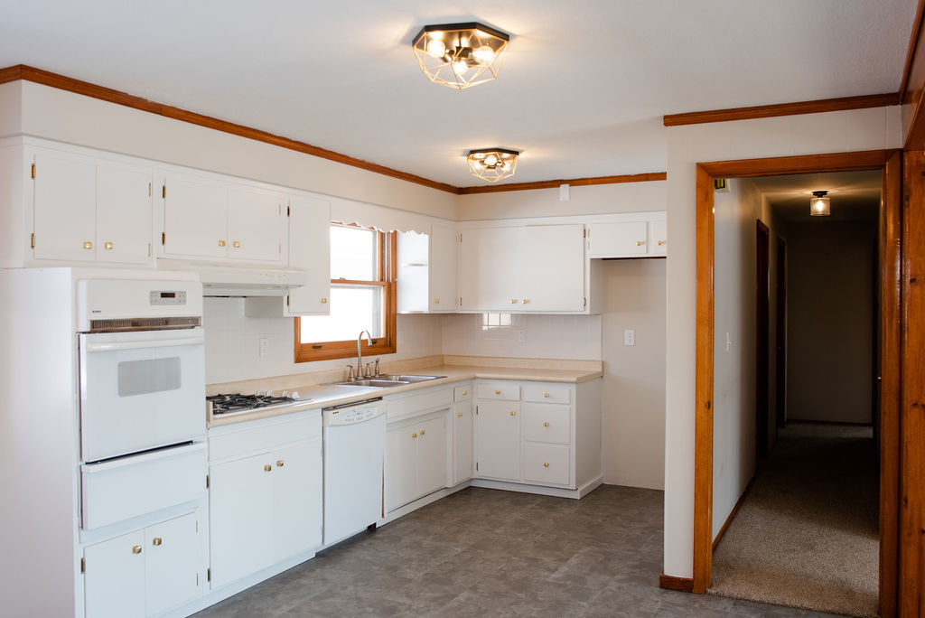 425 West Donald Street Kankakee, IL 60901 - Photo 4 of 14 a kitchen with white cabinets and white appliances