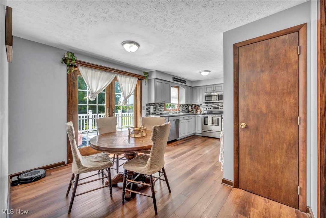 9827 Akron Road Rittman, OH 44270 - Photo 15 of 47 Dining area featuring light wood finished floors and a textured ceiling