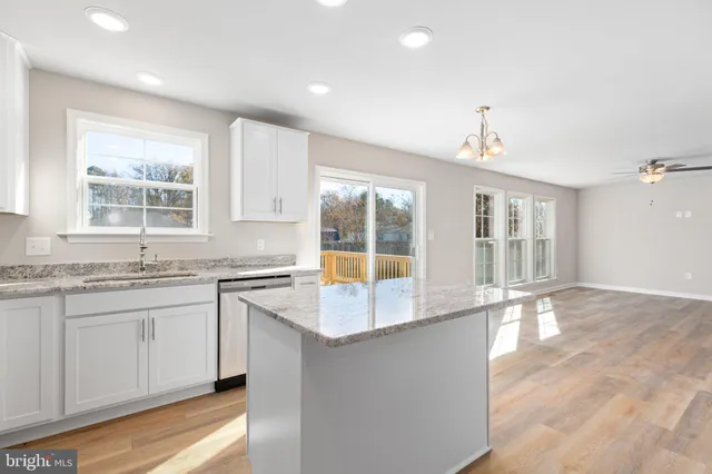 a large kitchen with granite countertop a sink and a stove top oven