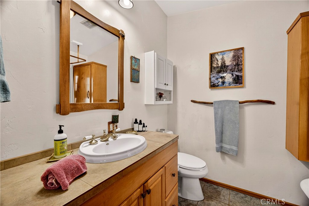 15001 Culiacan Court Forest Ranch, CA 95942 - Photo 19 of 66 a bathroom with a granite countertop sink mirror vanity and toilet