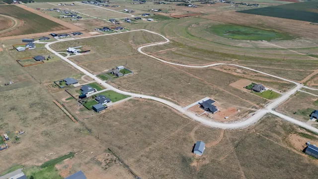 an aerial view of a wooden house with a yard