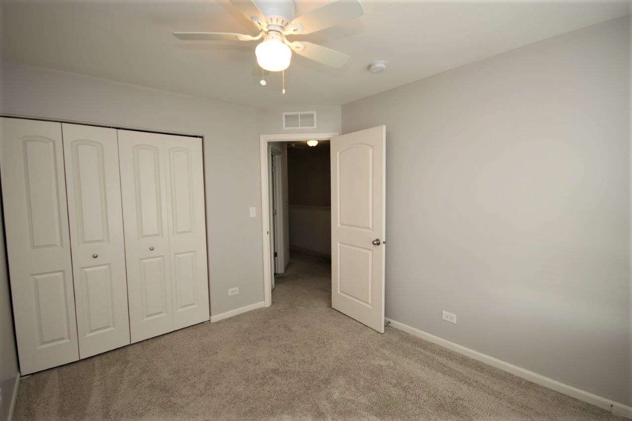 1785 Ruby Drive Pingree Grove, IL 60140 - Photo 12 of 24 an empty room with closet and a ceiling fan