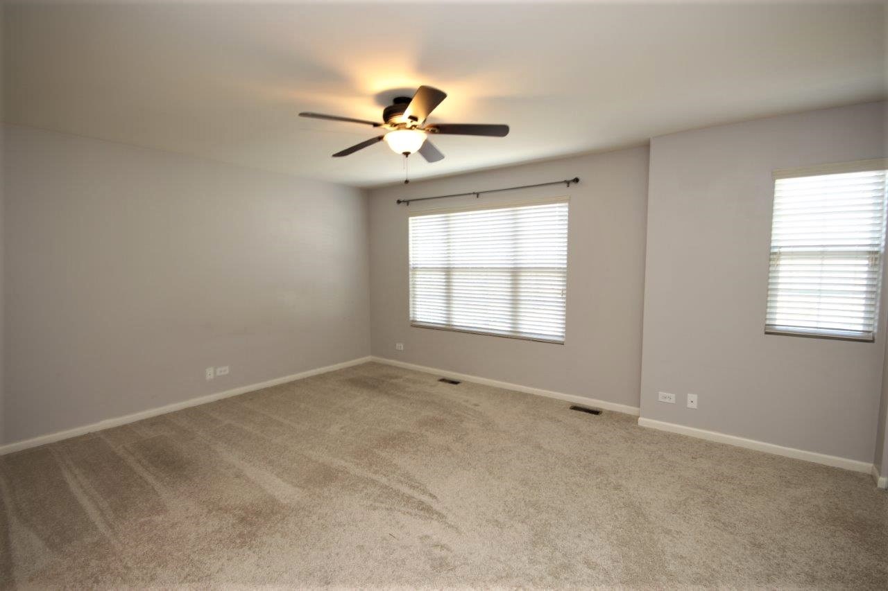 1785 Ruby Drive Pingree Grove, IL 60140 - Photo 7 of 24 an empty room with windows and fan