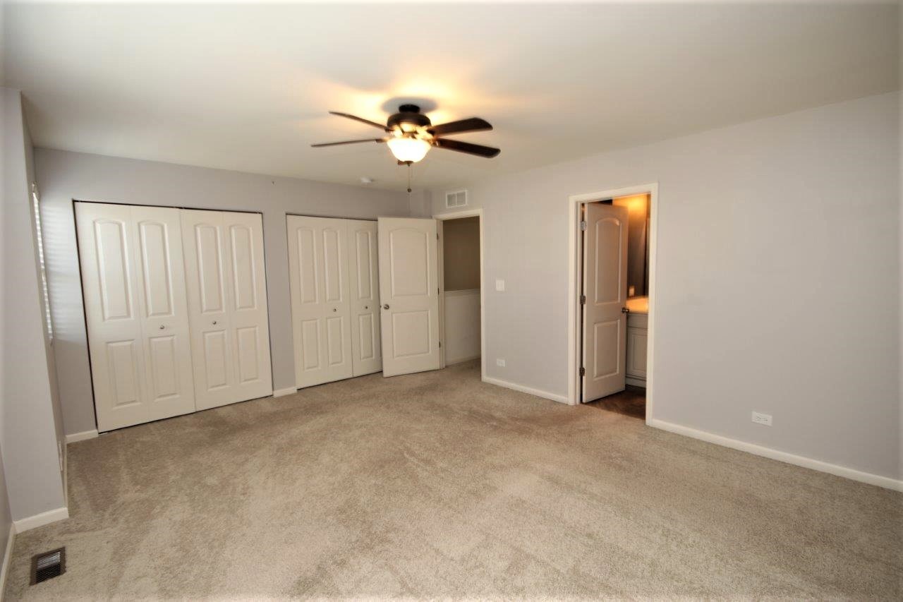 1785 Ruby Drive Pingree Grove, IL 60140 - Photo 8 of 24 an empty room with closet and a chandelier fan