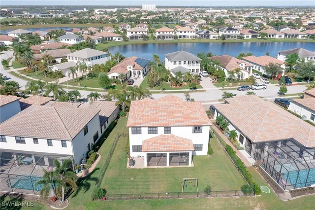 an aerial view of a house with outdoor space and lake view in back