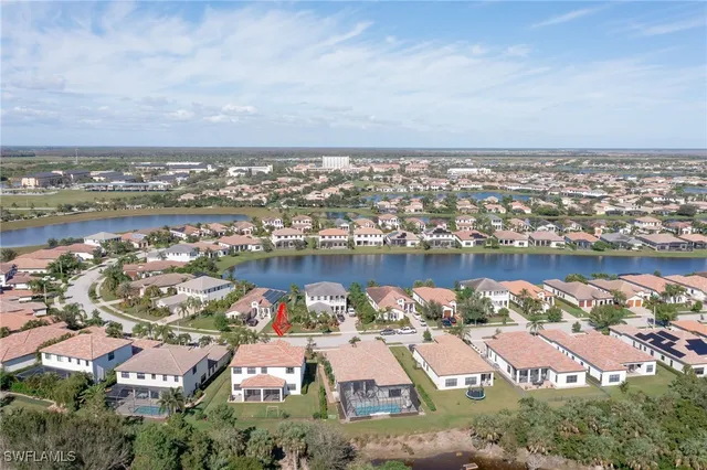 an aerial view of residential houses with outdoor space and lake view
