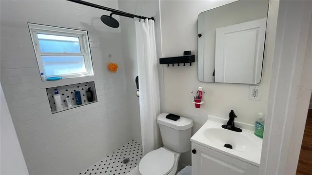 a bathroom with a sink toilet and shower
