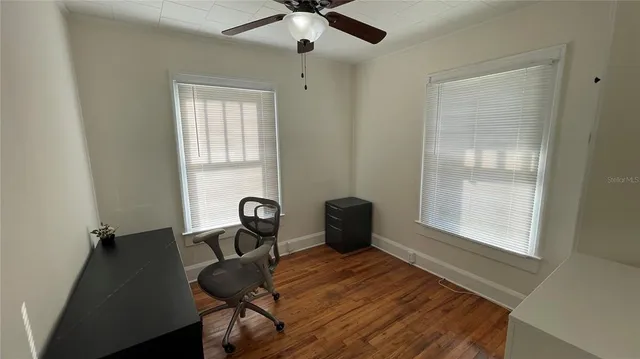 a view of a workspace with furniture and a window