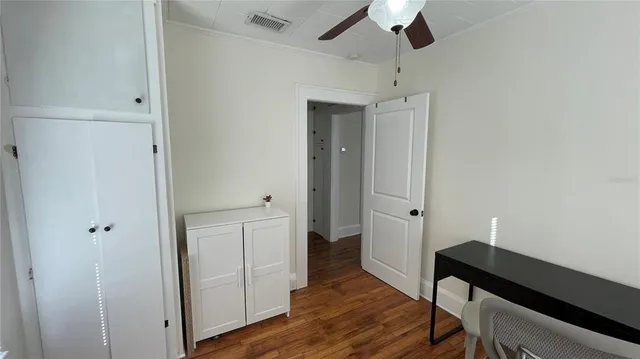 a view of a livingroom with wooden floor and bedroom