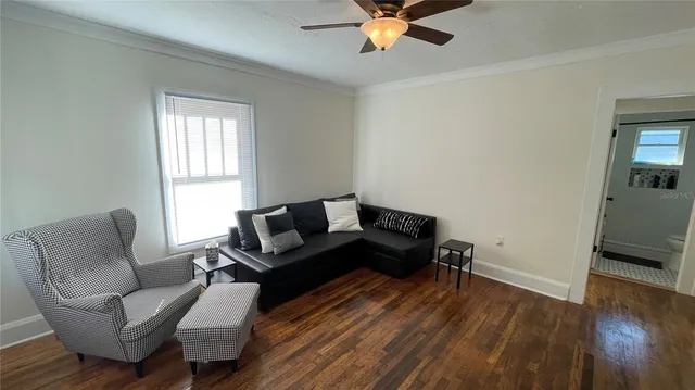 a living room with furniture and a wooden floor
