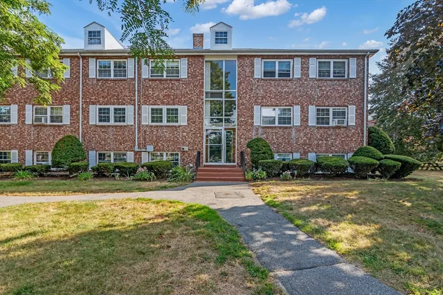 front view of a brick house with a yard