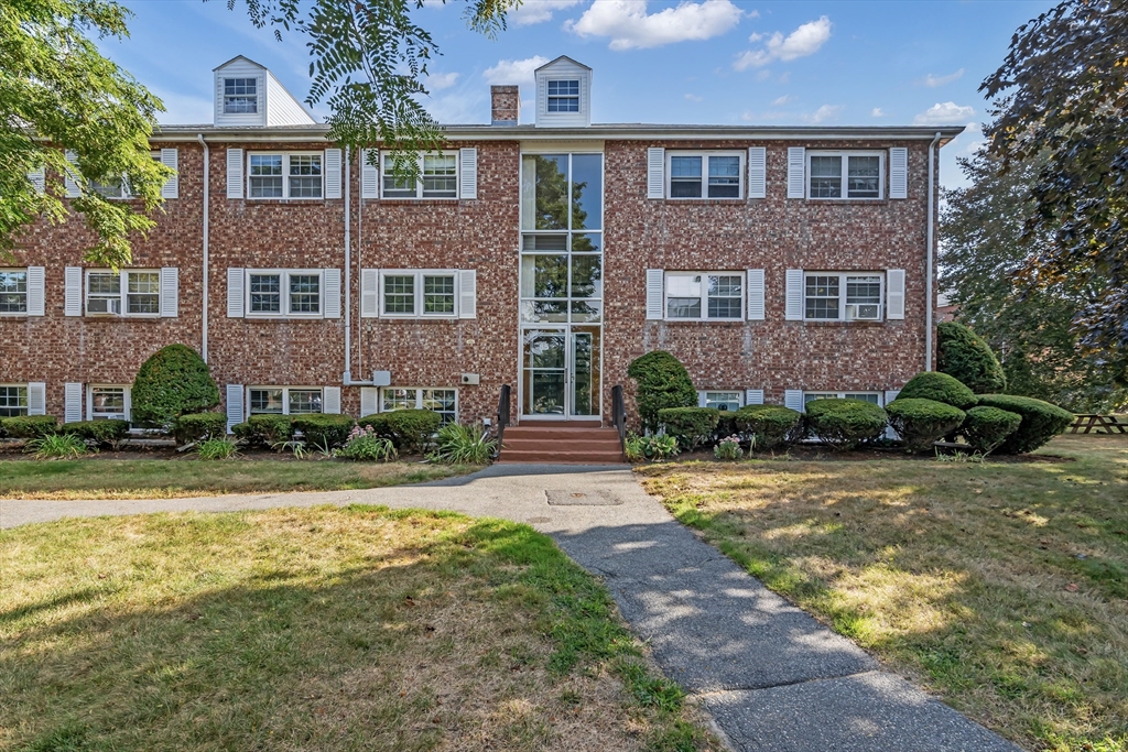 front view of a brick house with a yard