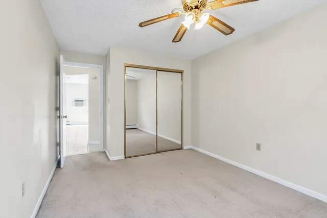a view of an empty room and chandelier fan