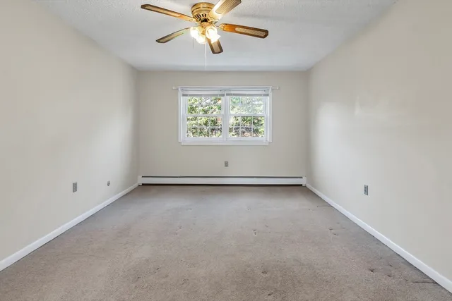 an empty room with a window and a fan