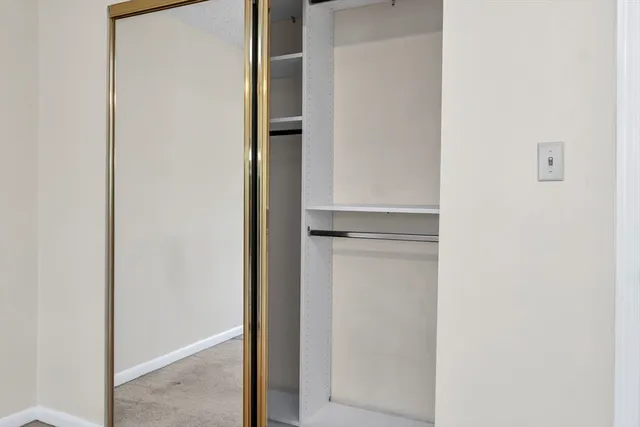 a view of walk in closet with empty racks