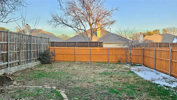 a view of a backyard with wooden fence