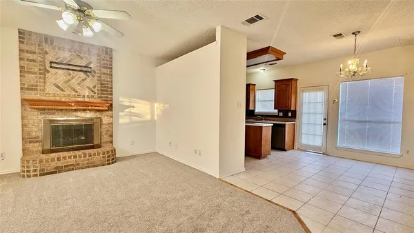 an empty room with windows and fireplace