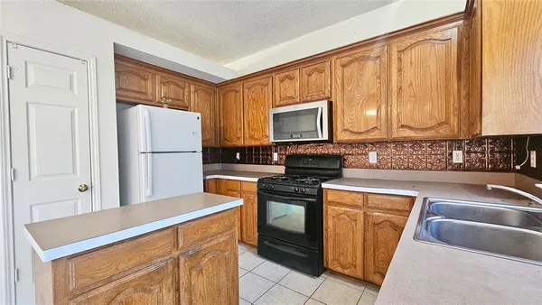 a kitchen with stainless steel appliances granite countertop a refrigerator stove top oven and sink