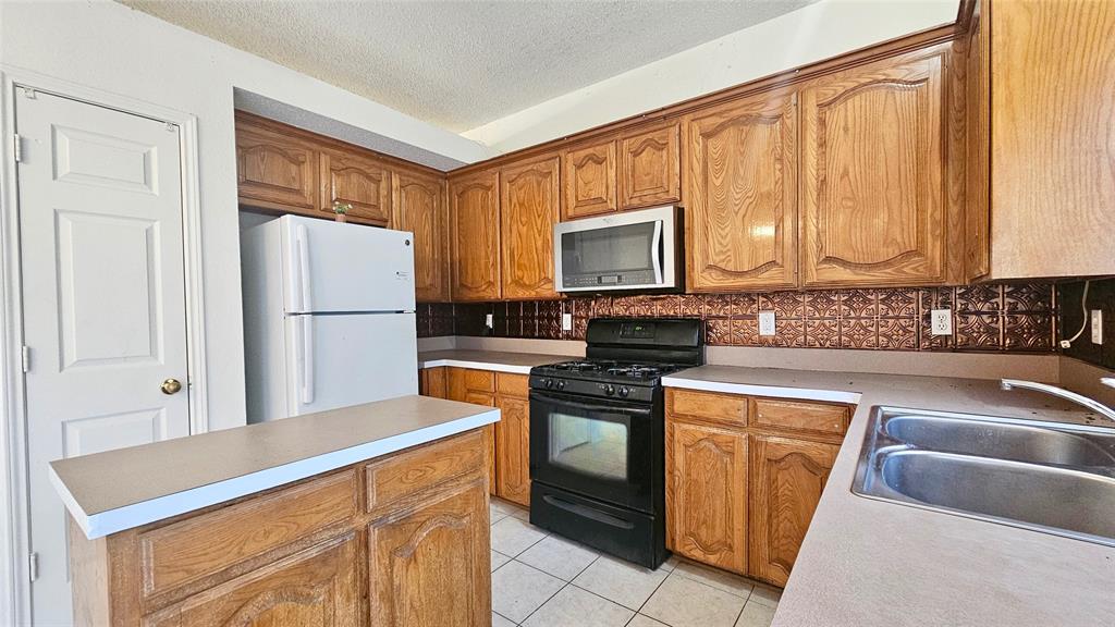 7640 Tournament Road Frisco, TX 75035 - Photo 5 of 25 a kitchen with stainless steel appliances granite countertop a refrigerator stove top oven and sink