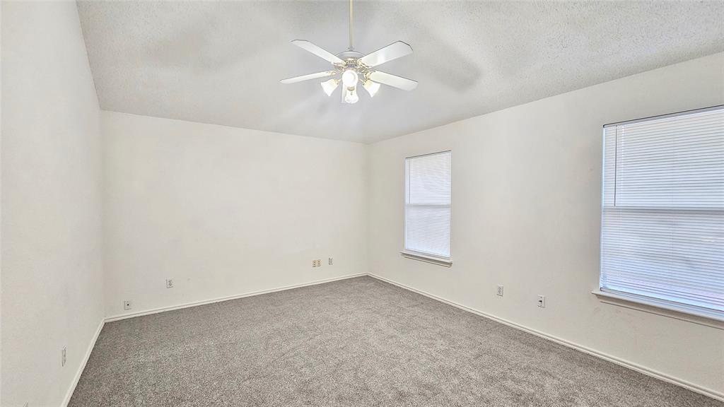 7640 Tournament Road Frisco, TX 75035 - Photo 10 of 25 an empty room with chandelier fan and windows