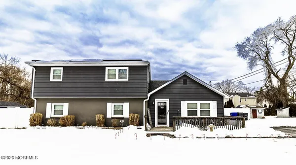 a front view of a house with a yard covered in snow