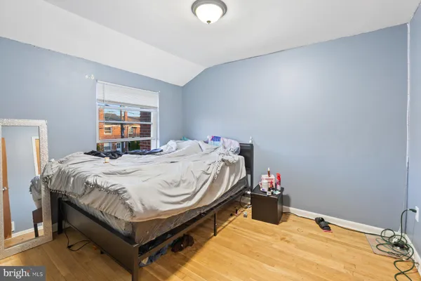 a bed sitting in a bedroom next to a window and a chandelier