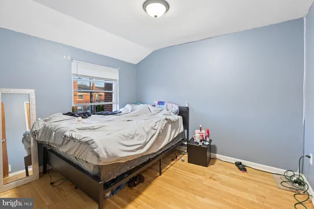 a bed sitting in a bedroom next to a window and a chandelier