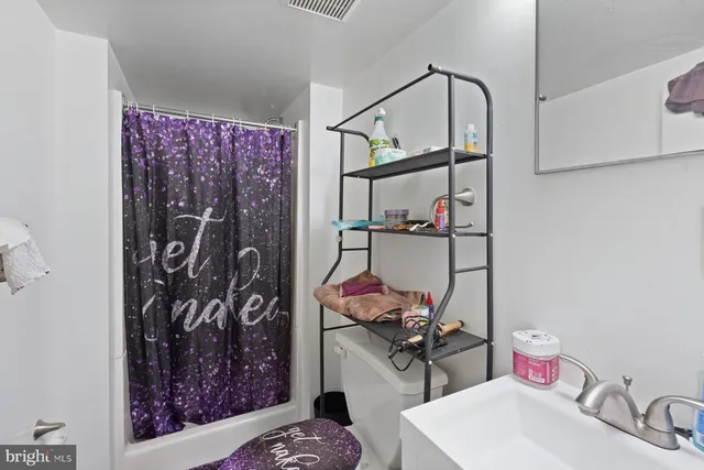 a bathroom with a sink vanity mirror and toilet