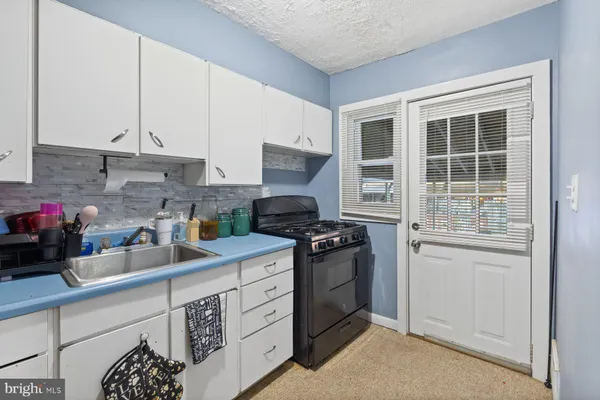 a kitchen with stainless steel appliances granite countertop a sink stove and cabinets