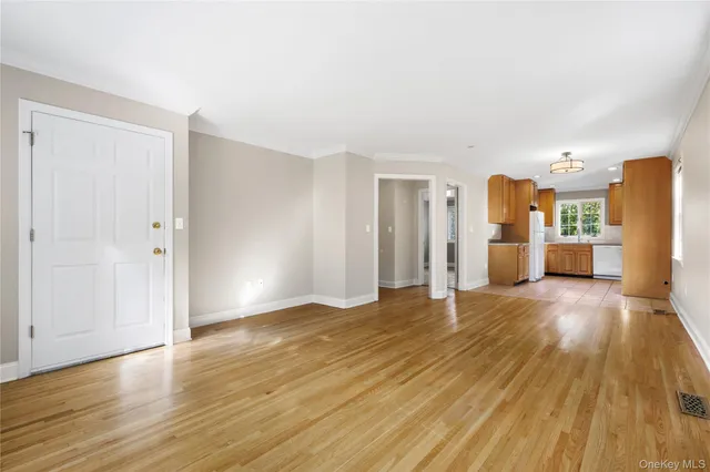 a view of a kitchen with a fridge and wooden floor