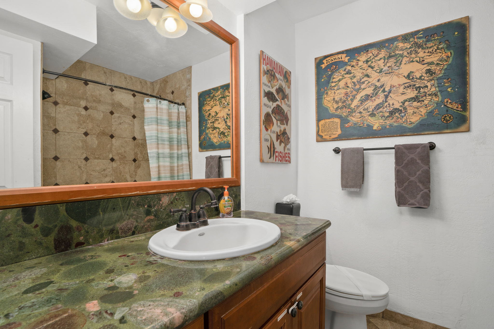 5050 Lawai Road, Unit 311 Koloa, HI 96756 - Photo 15 of 21 a bathroom with a granite countertop sink a toilet a mirror and a shower