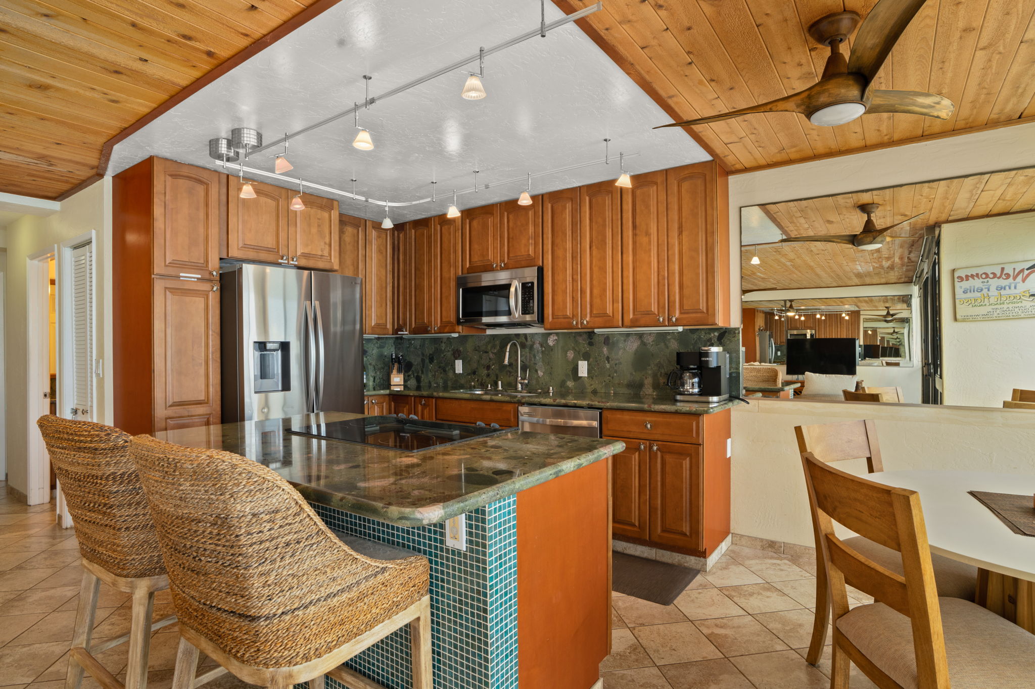 5050 Lawai Road, Unit 311 Koloa, HI 96756 - Photo 5 of 21 a kitchen with stainless steel appliances granite countertop a table chairs and a refrigerator