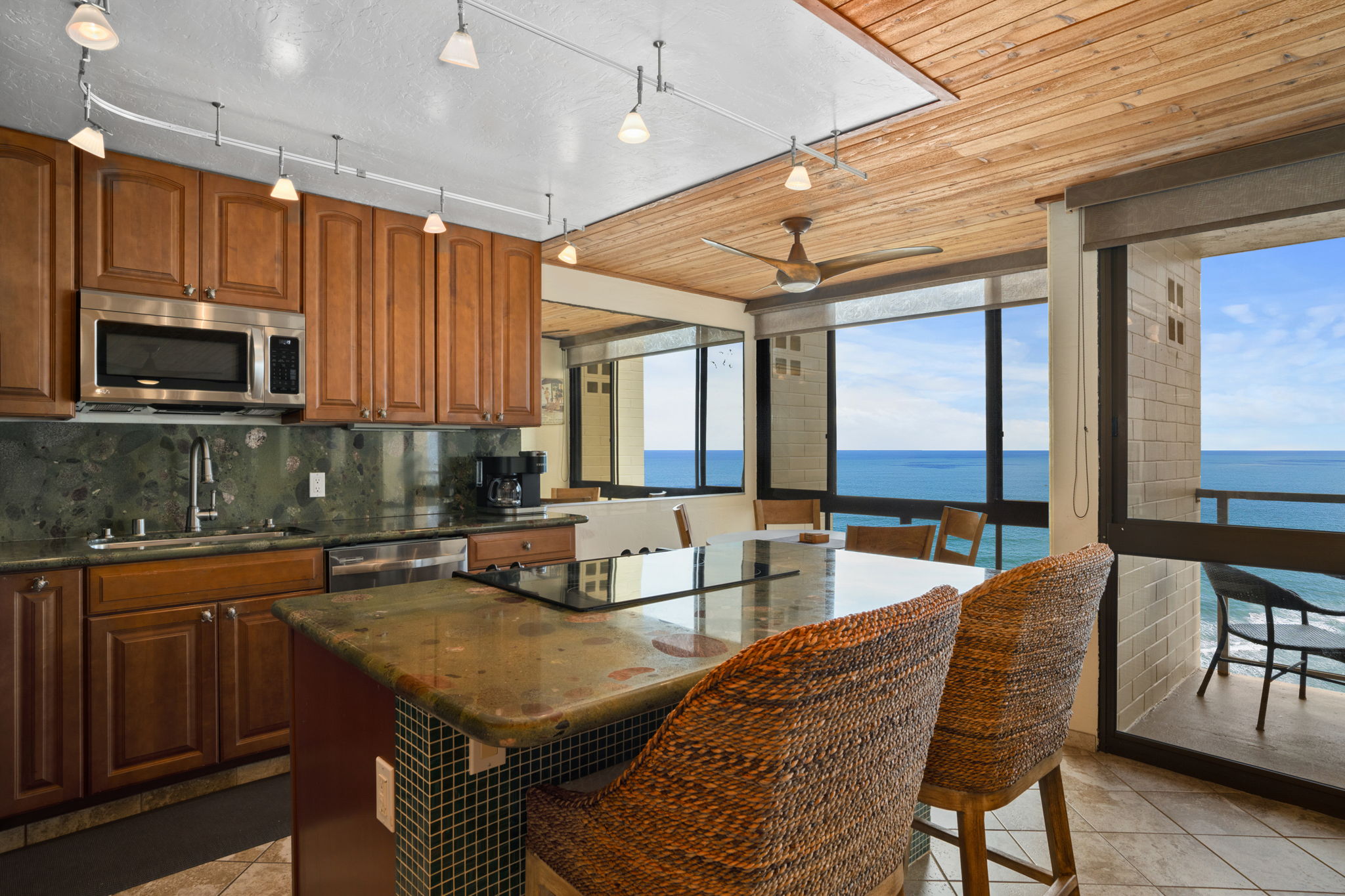 5050 Lawai Road, Unit 311 Koloa, HI 96756 - Photo 6 of 21 a kitchen with stainless steel appliances granite countertop a stove a sink dishwasher a microwave oven with a dining table and chairs