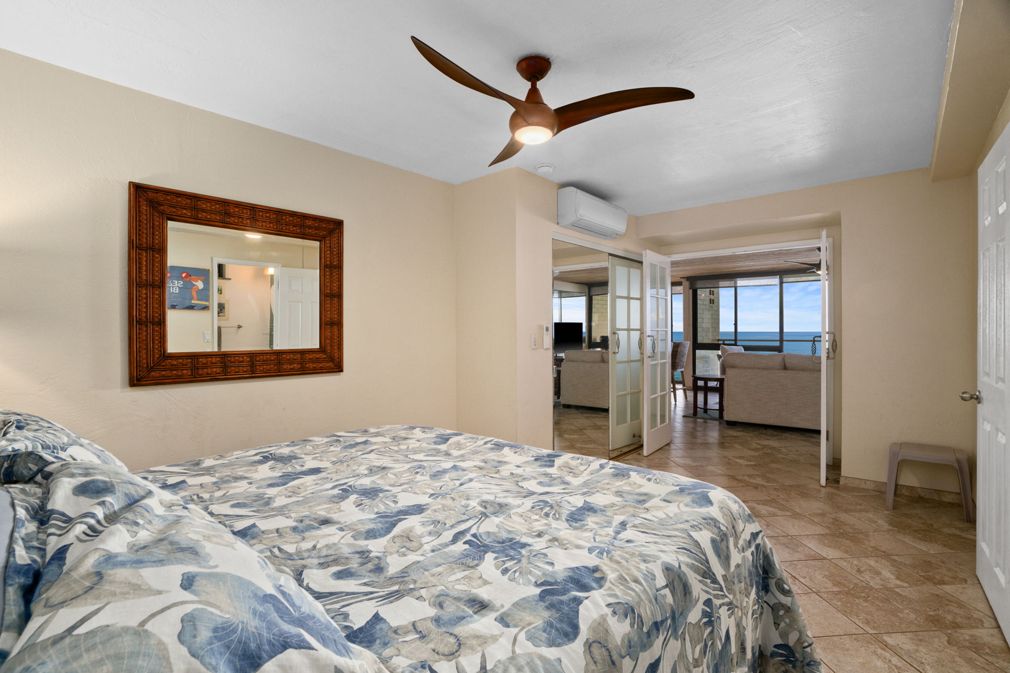 5050 Lawai Road, Unit 311 Koloa, HI 96756 - Photo 9 of 21 a bedroom with a large bed and a chandelier