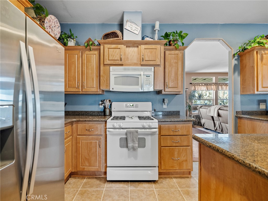 2826 Marco Road Phelan, CA 92371 - Photo 12 of 33 a kitchen with stainless steel appliances granite countertop a stove a sink and a refrigerator
