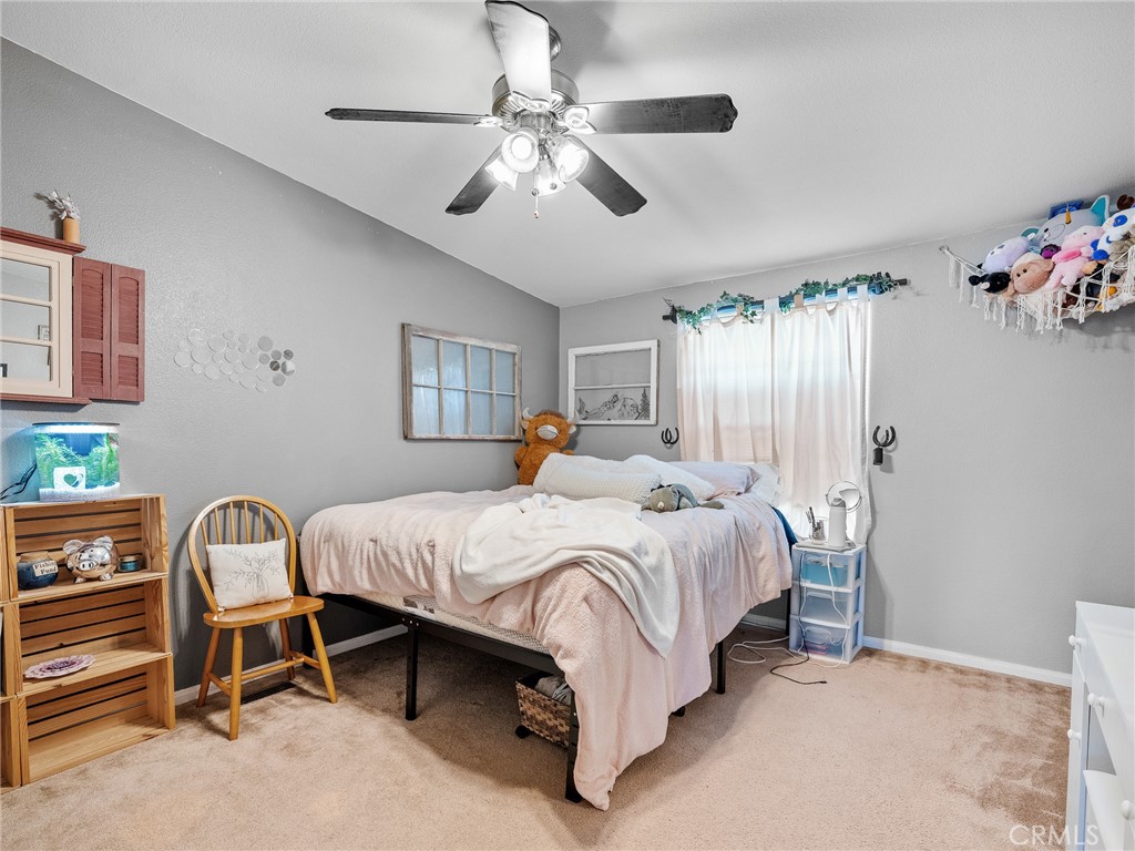 2826 Marco Road Phelan, CA 92371 - Photo 14 of 33 a spacious bedroom with a bed and a chandelier