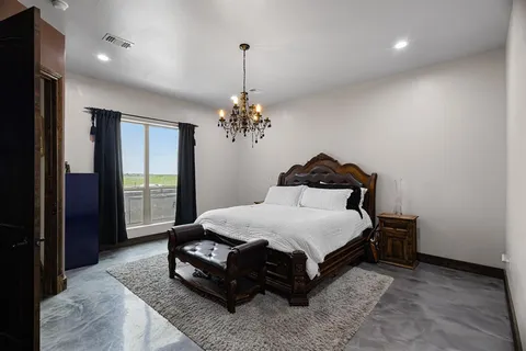 a spacious bedroom with a bed and a chandelier