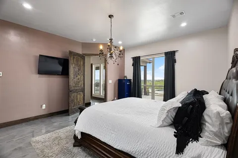 a spacious bedroom with a bed and a flat screen tv