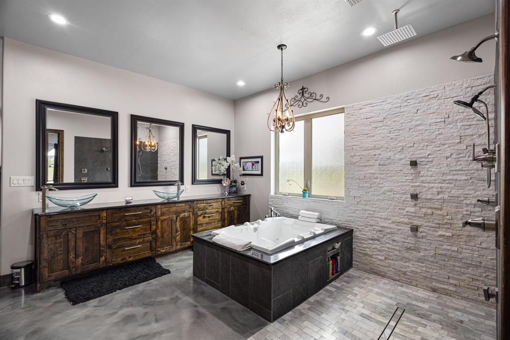 1395 Private Road 4011 Decatur, TX 76234 - Photo 16 of 34 a spacious bathroom with a double vanity sink large mirror and a bathtub