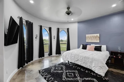 a bedroom with a large bed and a large mirror