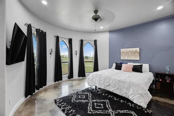 a bedroom with a large bed and a large mirror